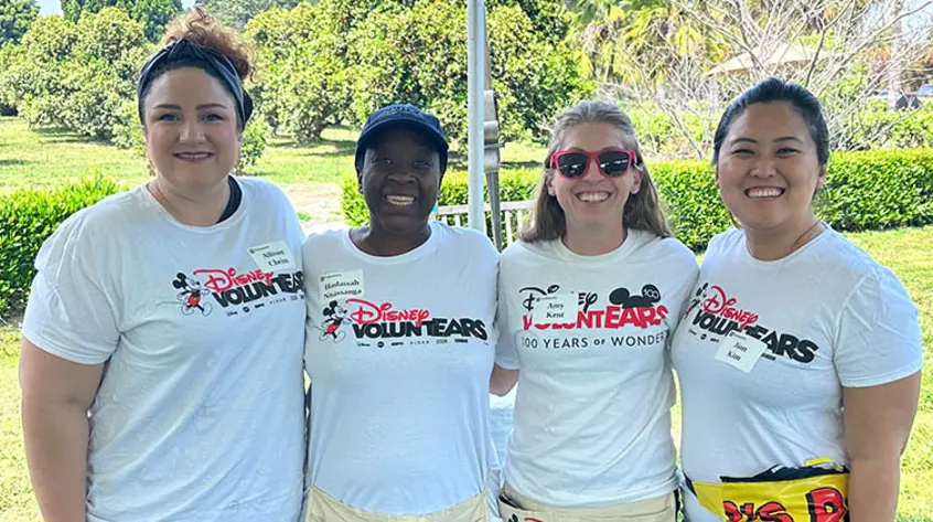 A group of people wearing tee shirts with the Disney VoluntEARS logo.