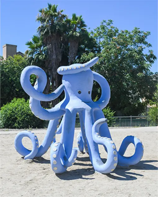 A blue octopus play structure with curling tentacles.