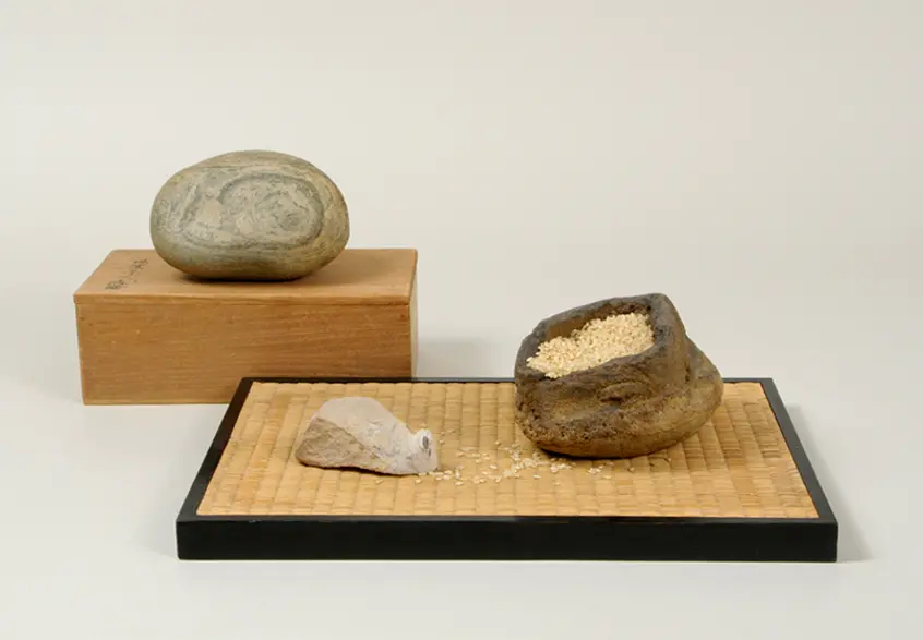 A small group of viewing stones, one resembles a white mouse, another looks like an open bag filled with grains of sand.