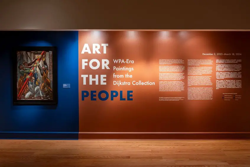 A gallery wall with a framed painting next to text that reads "Art for the People."
