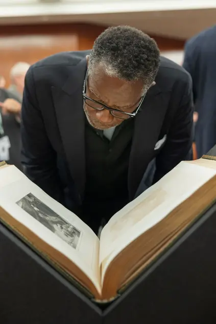 A man looks closely at a book.