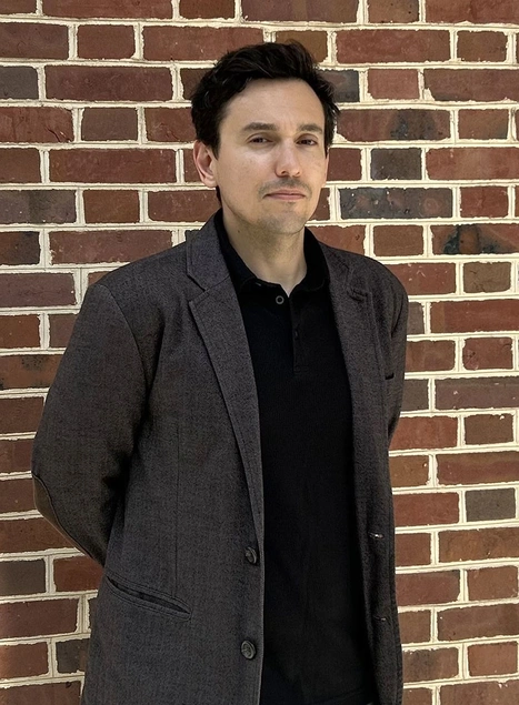 Headshot of Diego Godoy standing in front of a brick wall.