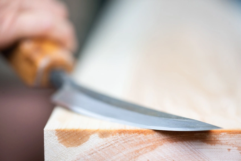 Close-up view of the blade of a tool against wood.