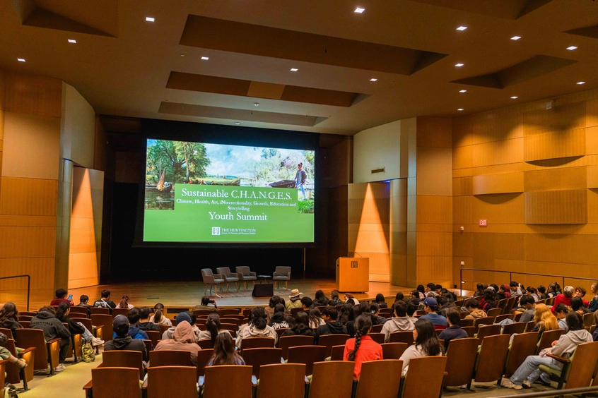 An auditorium with people in seats looking at a screen.