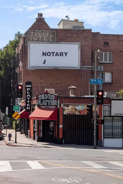 Larry Johnson, Notary, 2020. Billboard at South Rampart Boulevard and West Seventh Street, Los Angeles 90057 (facing north). 144 × 288 in. (365.8 × 731.5 cm). Courtesy of the artist, David Kordansky Gallery, Los Angeles, and 303 Gallery, New York. Installation view, Made in L.A. 2020: a version. Photo: Joshua White / JWPictures.com