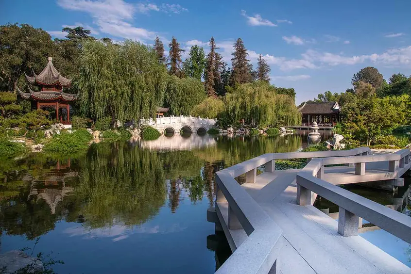View of the Lake of Reflected Fragrance, showing some of the original features that opened in 2008 (l–r): the Pavilion of the Three Friends, the Jade Ribbon Bridge, and the Hall of the Jade Camellia. In the foreground is the Bridge of the Joy of Fish. Photo by Martha Benedict. The Huntington Library, Art Museum, and Botanical Gardens.