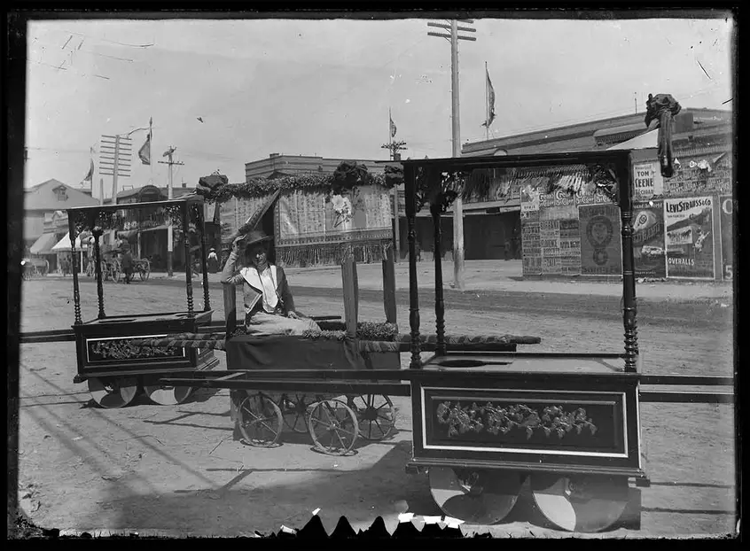 Unknown photographer, Western woman posing for a photograph on a ceremonial handcart, Old Chinatown, Los Angeles, 1902. The Huntington Library, Art Museum, and Botanical Gardens. 
