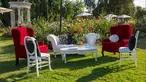 Velvet red high-back chairs sit among playful white chairs and couches.