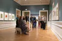 A group of people are gathered in an art gallery.