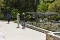 Two people look at a plant bed with a black silk sun cover.