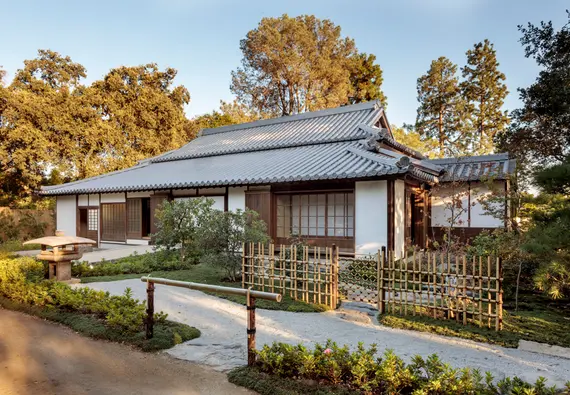 Rear view of a traditional Japanese home, with a gravel path and private garden.