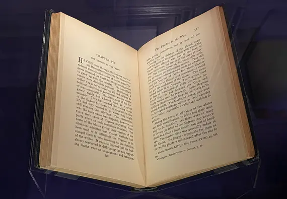 An open book in a glass case.