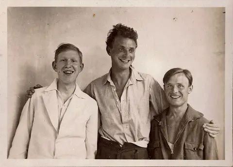 1930s black and white photo of three young men smiling for the camera.
