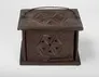 Brown wooden box foot-warmer with perforated star-shaped designs carved on its sides and top and a thin iron handle.