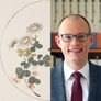 A composite image, on left an illustration of a flowering plant, on right a smiling man in a red tie.