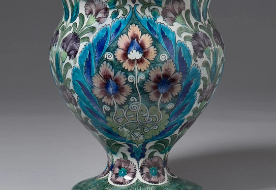 A ceramic vase with a multicolored, stylized botanical motif.