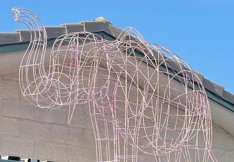 Pink wire shaped into the form of an elephant.