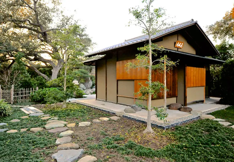 A house-like structure and a yard with stone paths and plants