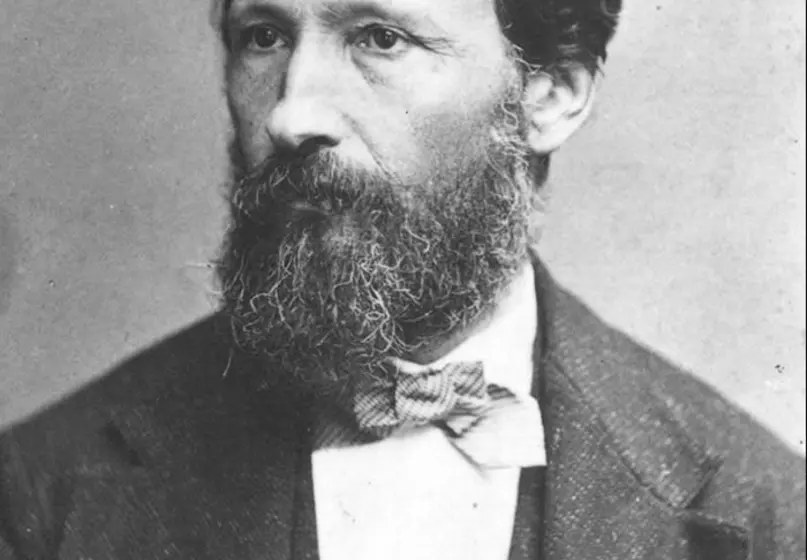 Black and white photograph of a person with a beard in a suit. Mansucript "Trouvelot." is written on the photograph.