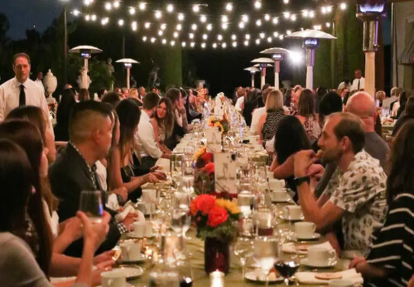 people gathered at an outside dinner table