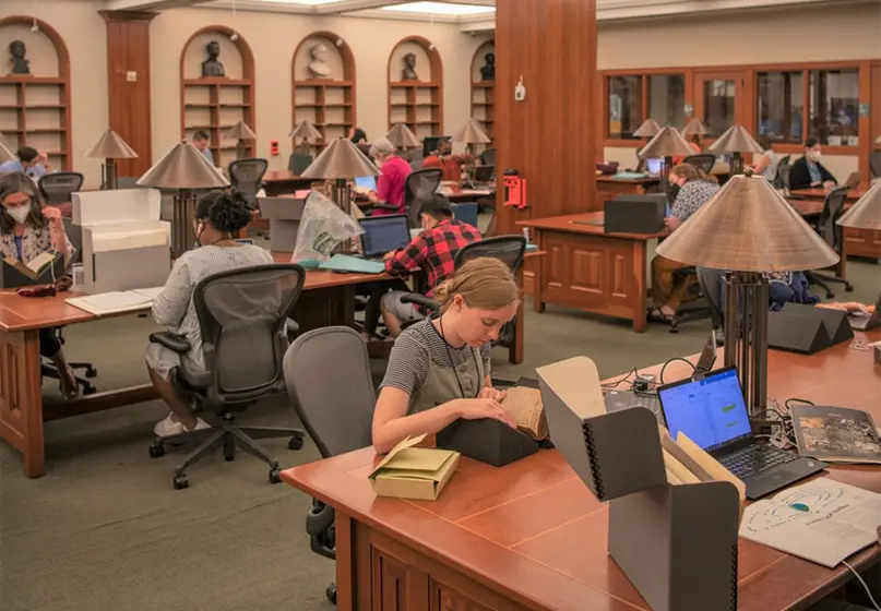 People sit at tables doing research in the Ahmanson Reading Room