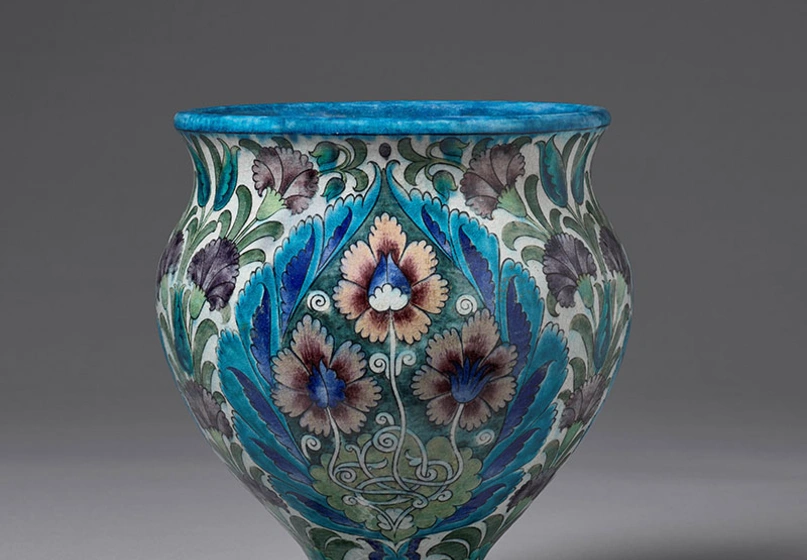 A beautifully detailed vase in blues, pinks, and greens.