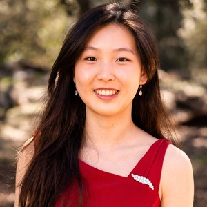 A person with long hair wearing a red top.