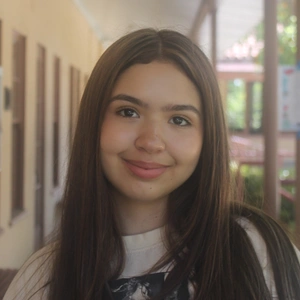 A smiling person with long hair.