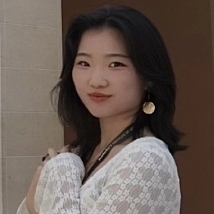 A smiling person in a white shirt.