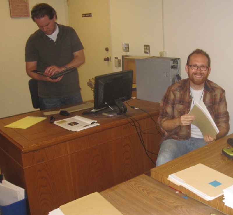 Erik Altenbernd (standing and holding a Turner family photo album) and Alex Young at work last year at The Huntington with the Turner papers.