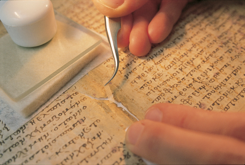 Pictured here, a conservator repairs a tear in a medieval manuscript<br />
 known as the Archimedes Palimpsest.