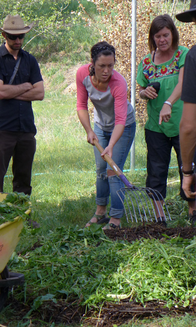 Workshop participant Kathryn Kocarnik (with pitchfork) combines nitrogen-producing weeds and vegetable scraps with layers of carbon-rich decomposed green waste