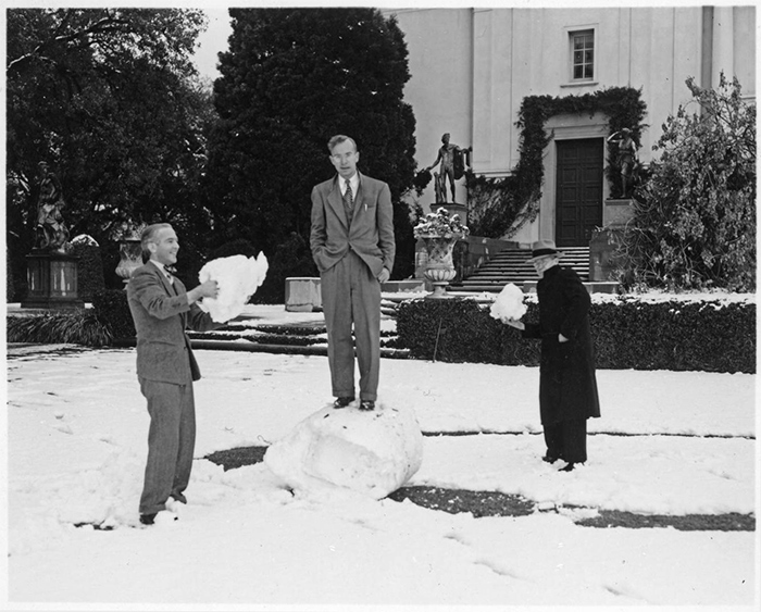 Employee Carey Bliss stands on a large ball of snow while colleagues Graydon Spalding and John Moslander hold smaller snowballs in their hands. (Jan. 11, 1949)