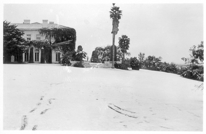 Snapshot of the west façade of the Huntington residence and the south terrace after a rare southern California snowfall. (Jan. 15, 1932)
