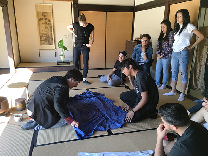 Torres students including Kenneth Morales (right) work with Robert Hori (left), The Huntington’s gardens cultural curator and program director, to fold a kimono inside the Japanese House. Torres engineering teacher Lindsay Weitzel, in black, looks on. Photo by Marissa Kucheck.