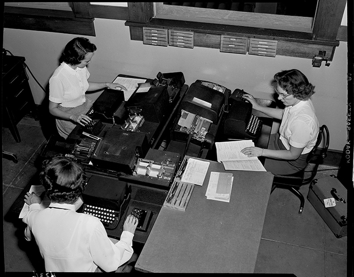 Edison photographer Doug White’s overhead shot of three computer key punch operators creating data entry cards, undated. Southern California Edison Archive. The Huntington Library, Art Collections, and Botanical Gardens.
