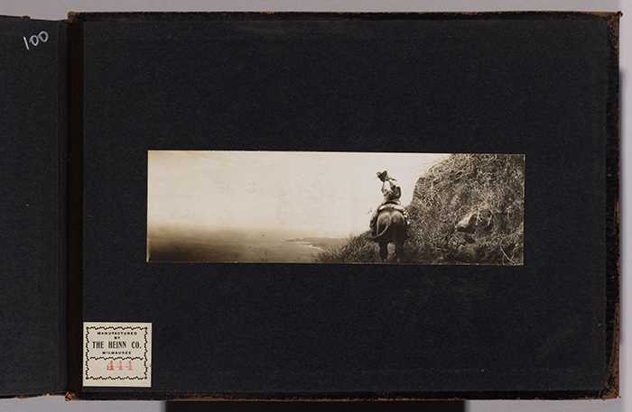 Charmian London on horseback at Molokai pali (cliff) with Kalaupapa peninsula visible in the distance, July 1907. Jack London Collection. The Huntington Library, Art Collections, and Botanical Gardens.