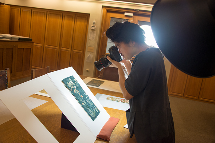 Soyoung Shin photographs a tapestry sample (ca. 1890) at The Huntington as part of her research. Photo by Kate Lain.