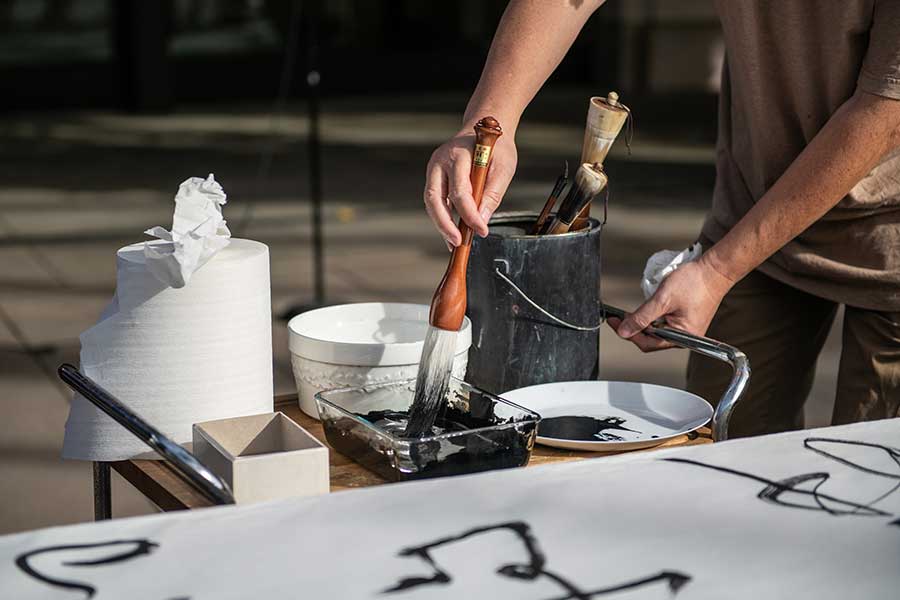 Tang Qingnian dips his brush into ink. Photo by Jamie Pham.