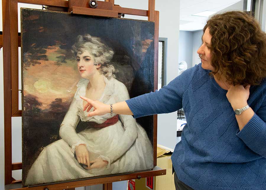 Melissa Gardner, associate conservator of paintings at the Museum of Fine Arts Houston, points toward a problematic area on the surface of The Huntington’s Lady Elizabeth Crichton, later Viscountess Mount-Stuart (ca. 1791), after Henry Raeburn. Photo by Deborah Miller.