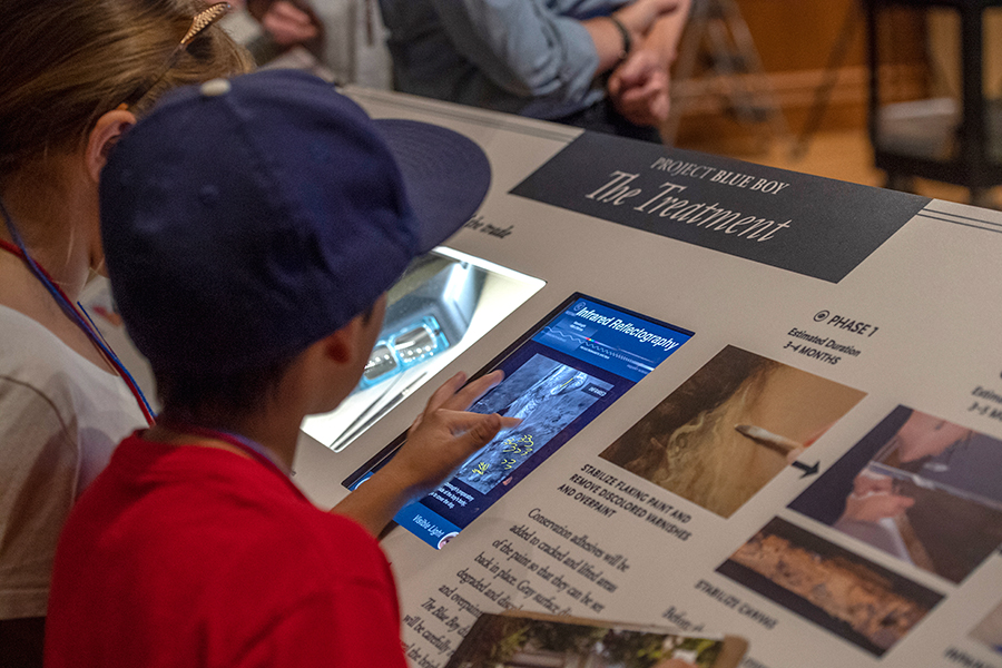 Student interacting with the infrared refractology image of The Blue Boy on a display in the Thornton Portrait Gallery. Photo by Martha Benedict.