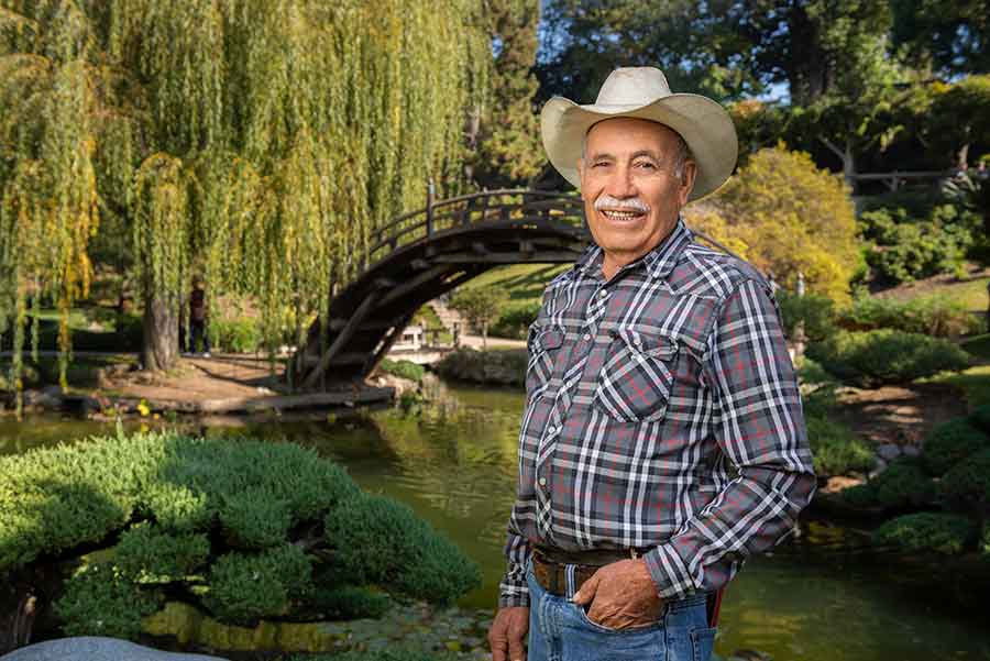 Ramiro Ramirez Pinedo, who has worked at The Huntington for 50 years, stands in his favorite place on the grounds, the Japanese Garden. Photo by Jamie Pham.