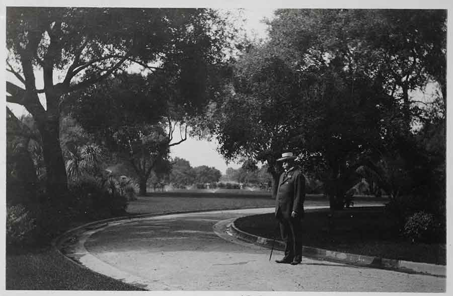 Henry E. Huntington (1850–1927), in about 1915, standing with the North Vista in the background. The Huntington Library, Art Museum, and Botanical Gardens.