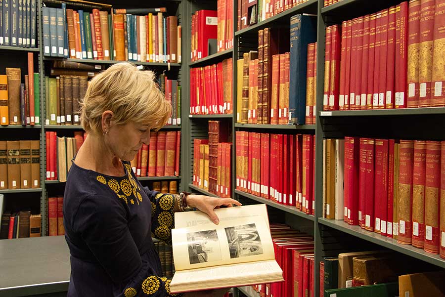 Lori Anne Ferrell, the John D. and Lillian Maguire Distinguished Professor in the Humanities at Claremont Graduate University and a 2018–19 Dana and David Dornsife Fellow at The Huntington, leafs through a volume of Victoria County History. Photo by Deborah Miller.